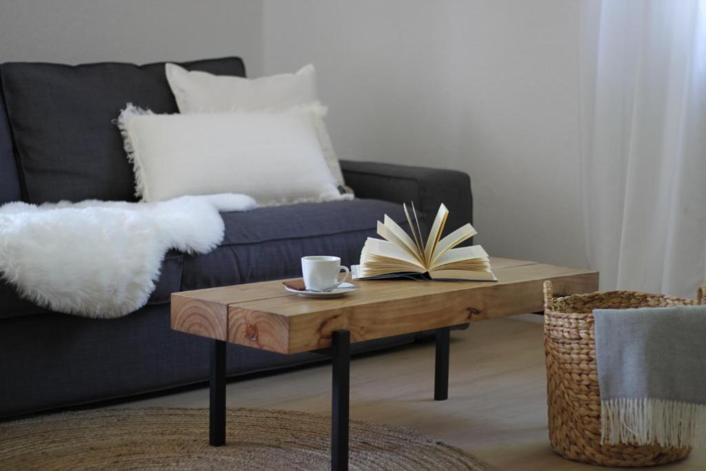 uma sala de estar com um sofá e uma mesa de centro com um livro em Vulkan-Nest in der Eifel em Ulmen