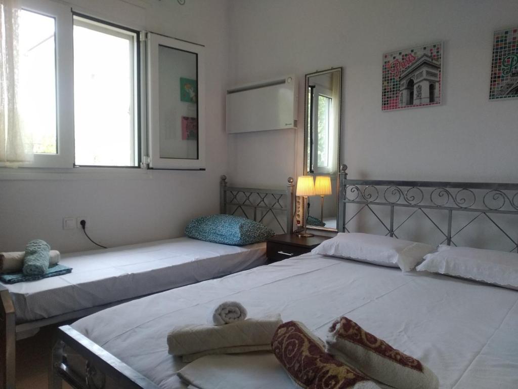 two beds in a room with two windows at IOANNIS SEASIDE VILLA in Leptokarya