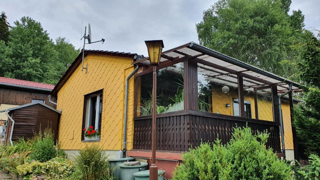 ein gelbes Haus mit einem großen Fenster darauf in der Unterkunft Ferienhaus Am Vitzerod in Tambach-Dietharz