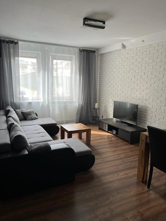 a living room with a couch and a flat screen tv at Mieszkanie Przy Deptaku in Świnoujście