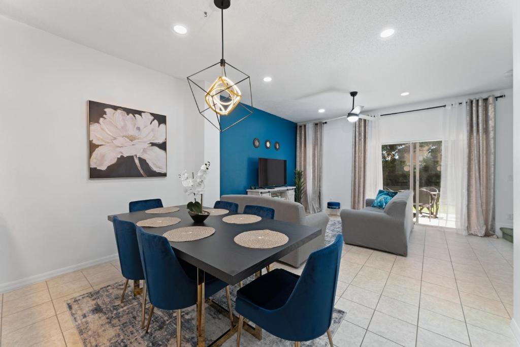 a dining room and living room with a table and chairs at JC DISNEY House in Kissimmee