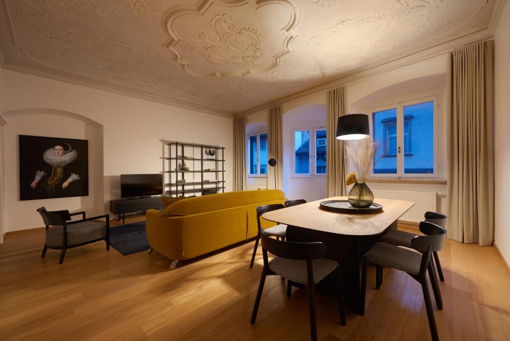 uma sala de estar com um sofá amarelo e uma mesa em Argentieri Apartment em Bolzano