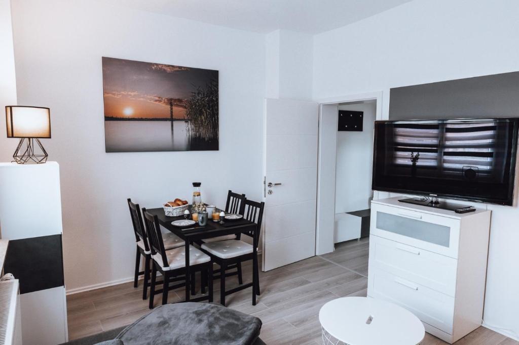 eine Küche und ein Esszimmer mit einem Tisch und Stühlen in der Unterkunft Ferienwohnung Goitzschezeit in Bitterfeld