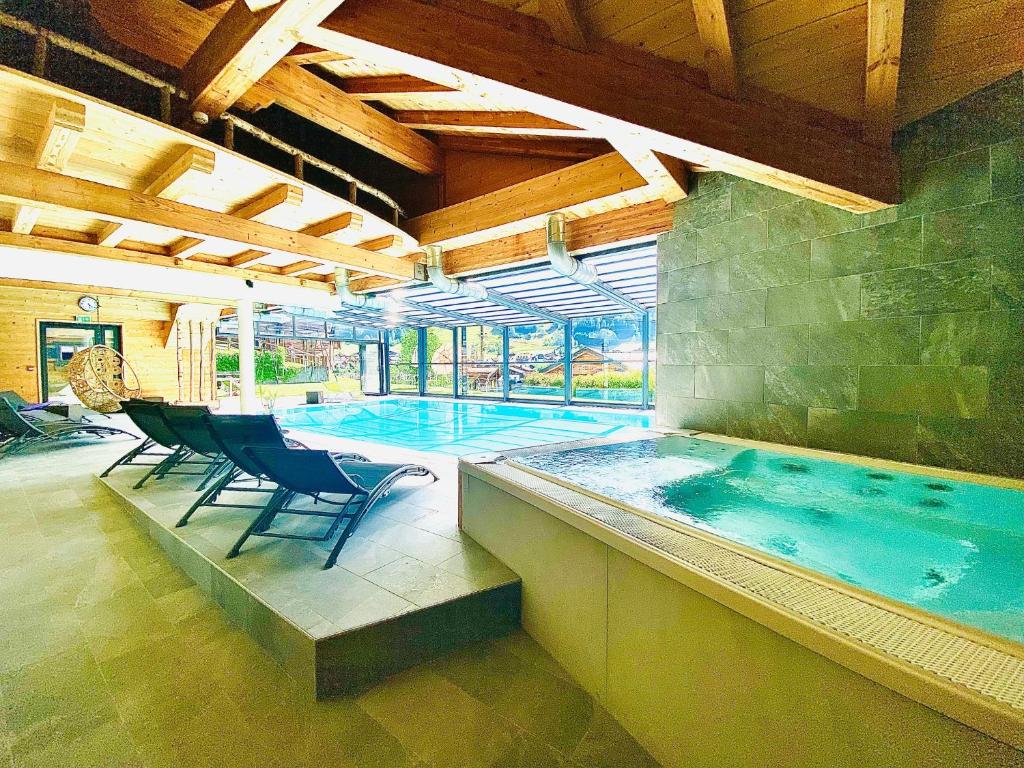 a large swimming pool with chairs in front of it at Hotel Alpina in Morzine