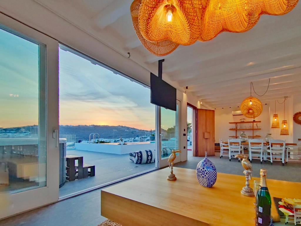 a living room with a large window and a dining room at SeaCode Villas in Platis Yialos Mykonos