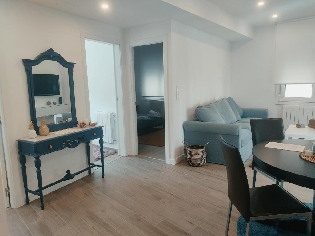 uma sala de estar com um sofá azul e um espelho em Apartamento Moaña La Playa, recién reformado em Moaña