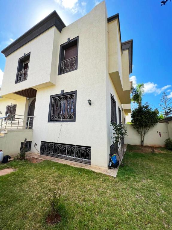 une grande maison blanche avec une cour dans l'établissement Beautiful Villa Casablanca, à Casablanca