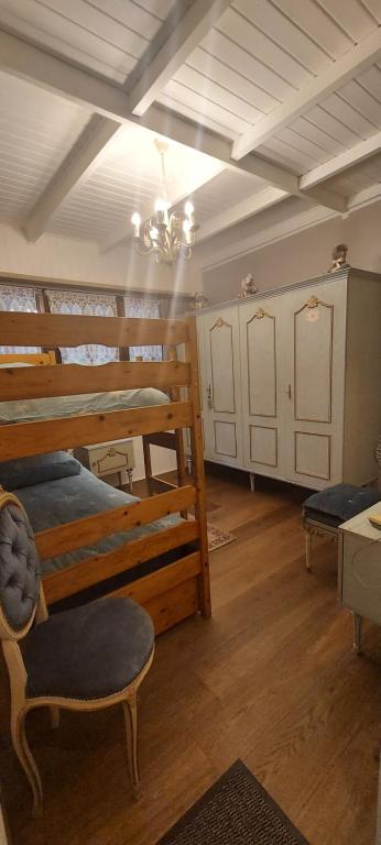a room with three bunk beds and a chandelier at &#39;T boshuisje in Opglabbeek