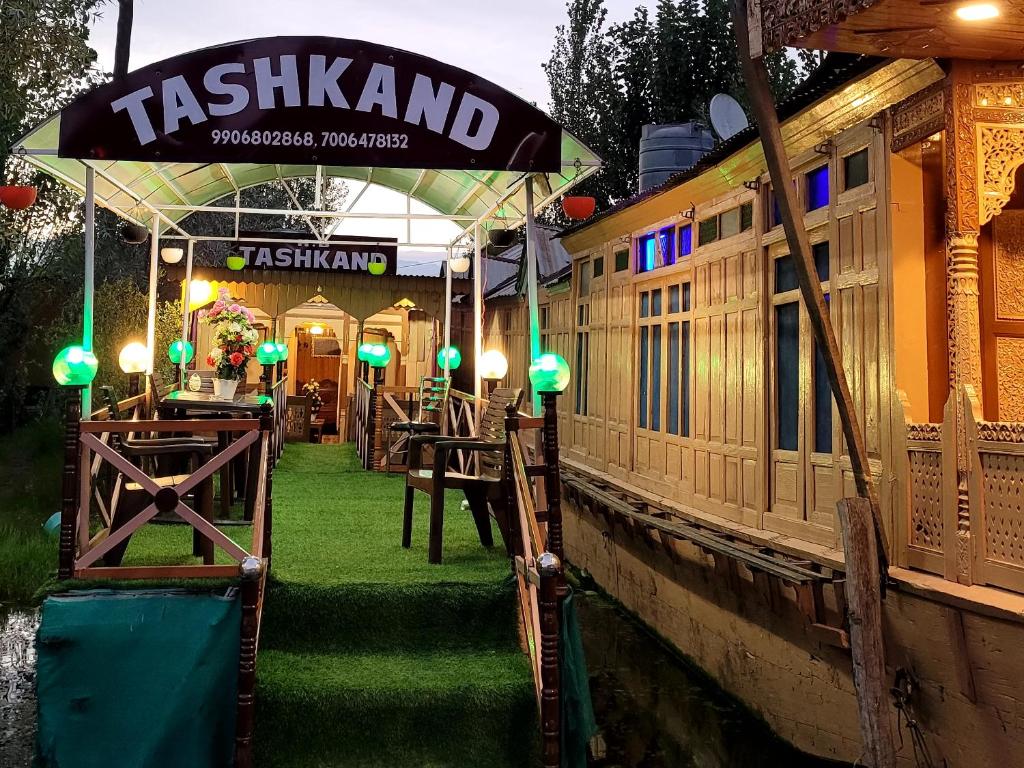 Tashkand Houseboat في سريناغار: مطعم ذو اضاءة خضراء على جانب قناة