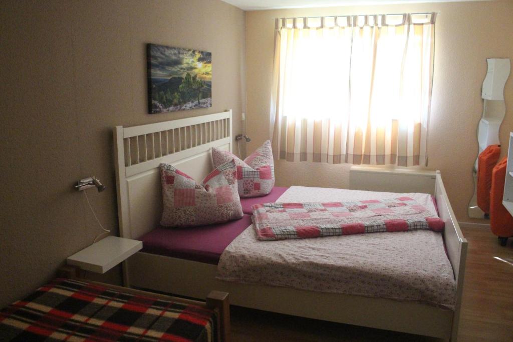 een kleine slaapkamer met een bed en een raam bij Basislager Hohnstein - Familie Lösel in Ehrenberg