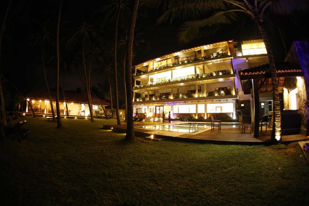 un hotel de noche con sus luces encendidas en Blue Beach Hotel, en Wadduwa