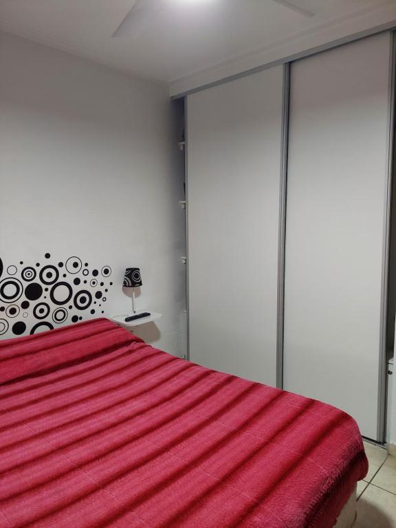 - une chambre avec un lit rouge et des portes coulissantes en verre dans l'établissement Departamento Viamonte con cochera, à Bahía Blanca