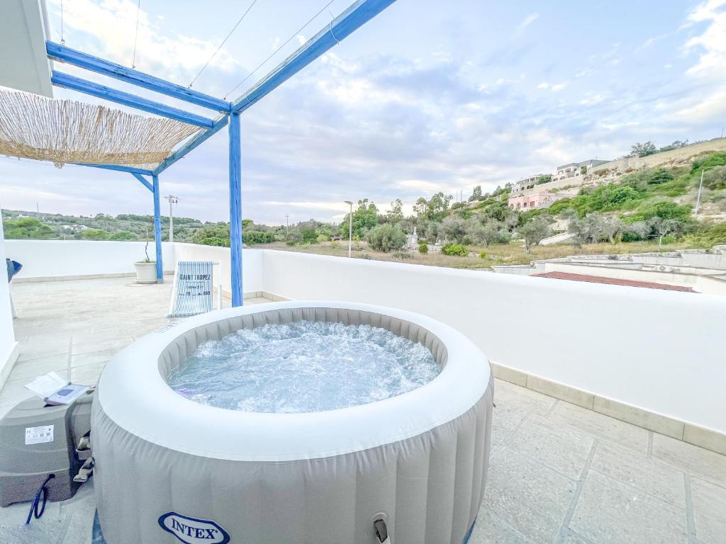 a large hot tub on the balcony of a house at Gyaaim in Castro di Lecce