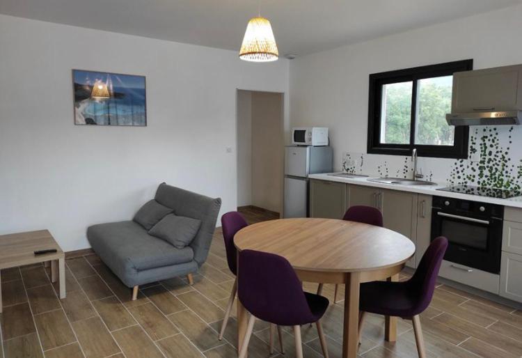 a kitchen and dining room with a table and a couch at Villa Jade in Sartène