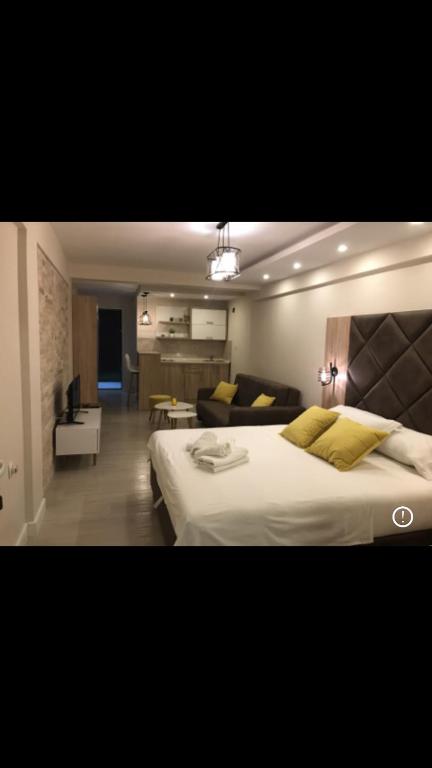 um quarto com uma cama grande e uma sala de estar em Apartmani Ada Bojana em Ulcinj