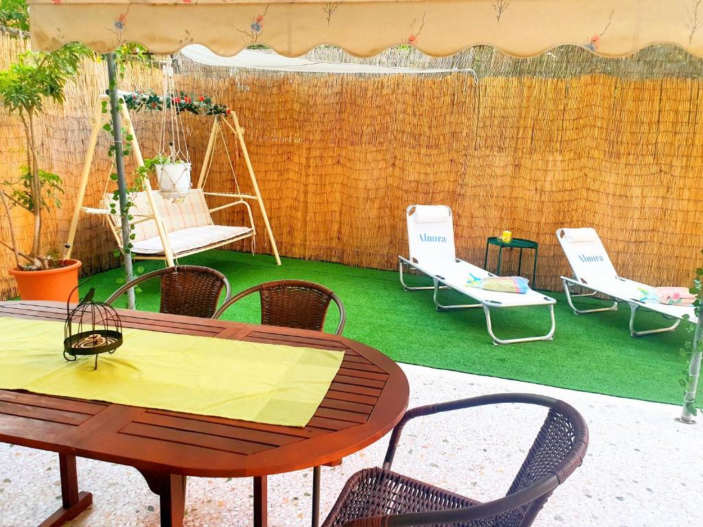 a patio with a table and chairs and a fence at Dolce Casa: Athenian Residence with private Garden in Athens