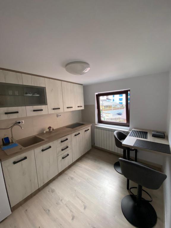 a kitchen with white cabinets and a desk with a laptop at Garsonierele Scandinav in Predeal