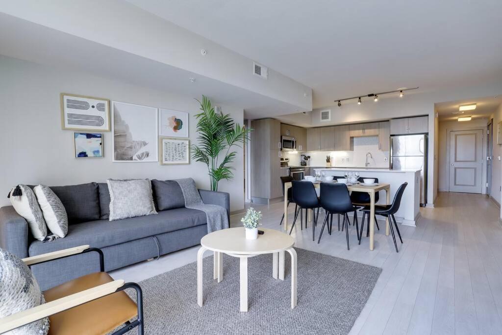 a living room with a blue couch and a table at Fantastic 2BR Condo At Crystal City With Rooftop in Arlington