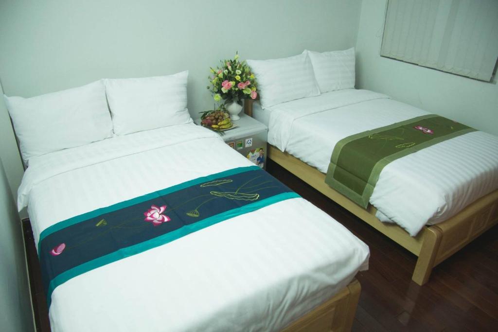 two beds sitting next to each other in a room at VIETNAM APPLE HOMESTAY in Hanoi