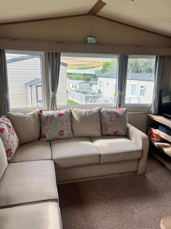 a living room with a couch in front of a window at Oakley Newquay Bay Resorts in Newquay Bay Resort