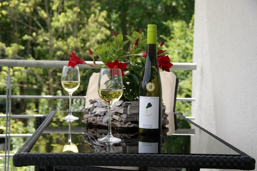 butelkę wina i dwa kieliszki na stole w obiekcie Ferienwohnung Sternenwald w mieście Alf