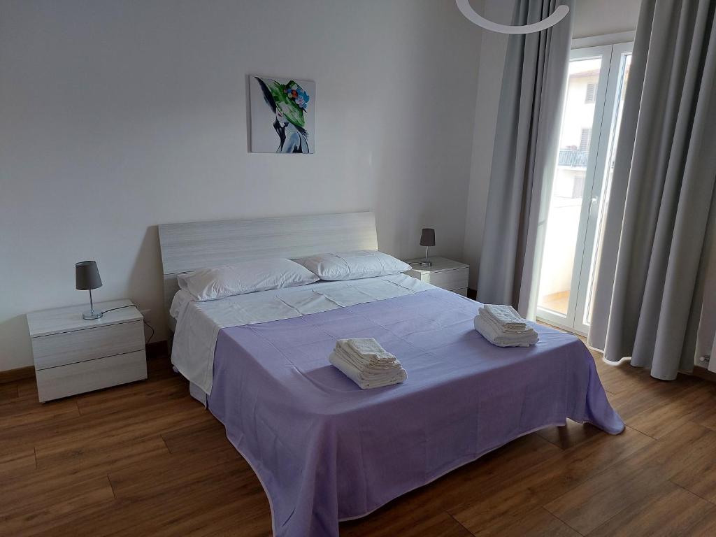 een slaapkamer met een groot bed en een paarse deken bij Alice apartment in Salemi