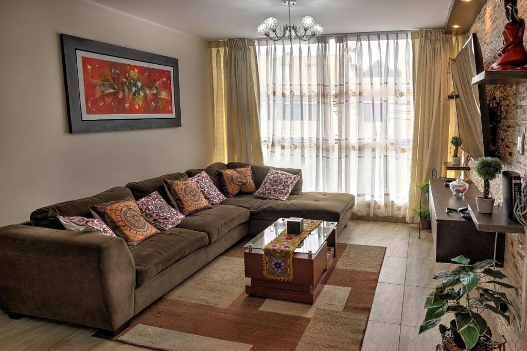 a living room with a couch and a coffee table at Dpto entero, 2do piso, ascensor, jacuzzi y cochera in Lima