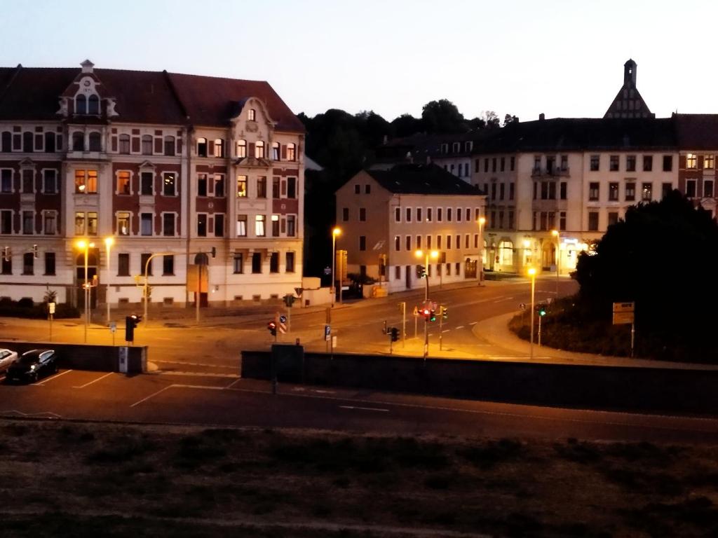 a city street with buildings and street lights at night at Hostel Meissen Old Town Bridge in Meißen