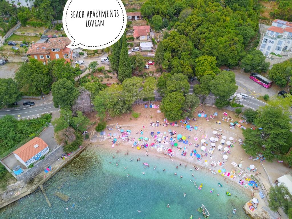 een luchtzicht op een strand met parasols en mensen bij Beach Apartments Lovran in Lovran