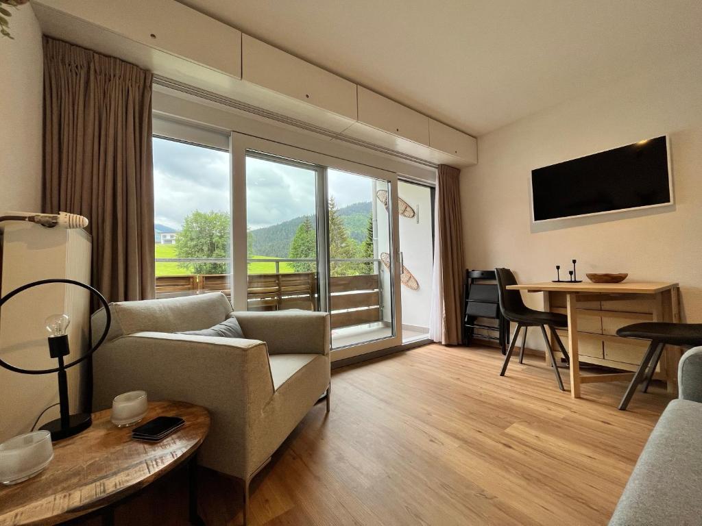 ein Wohnzimmer mit einem Sofa und einem großen Fenster in der Unterkunft Alpen Studio Ellmau in Ellmau