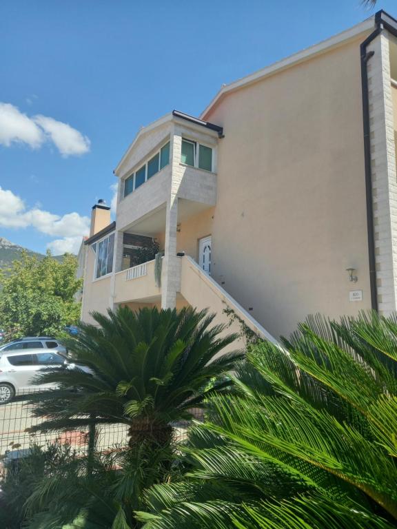a building with a palm tree in front of it at Apartman Maja in Kaštela
