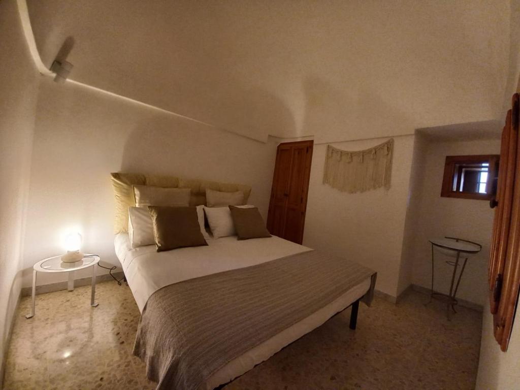 1 dormitorio con 1 cama y 1 lámpara en una mesa en Trulli Pinnacoli, en Locorotondo