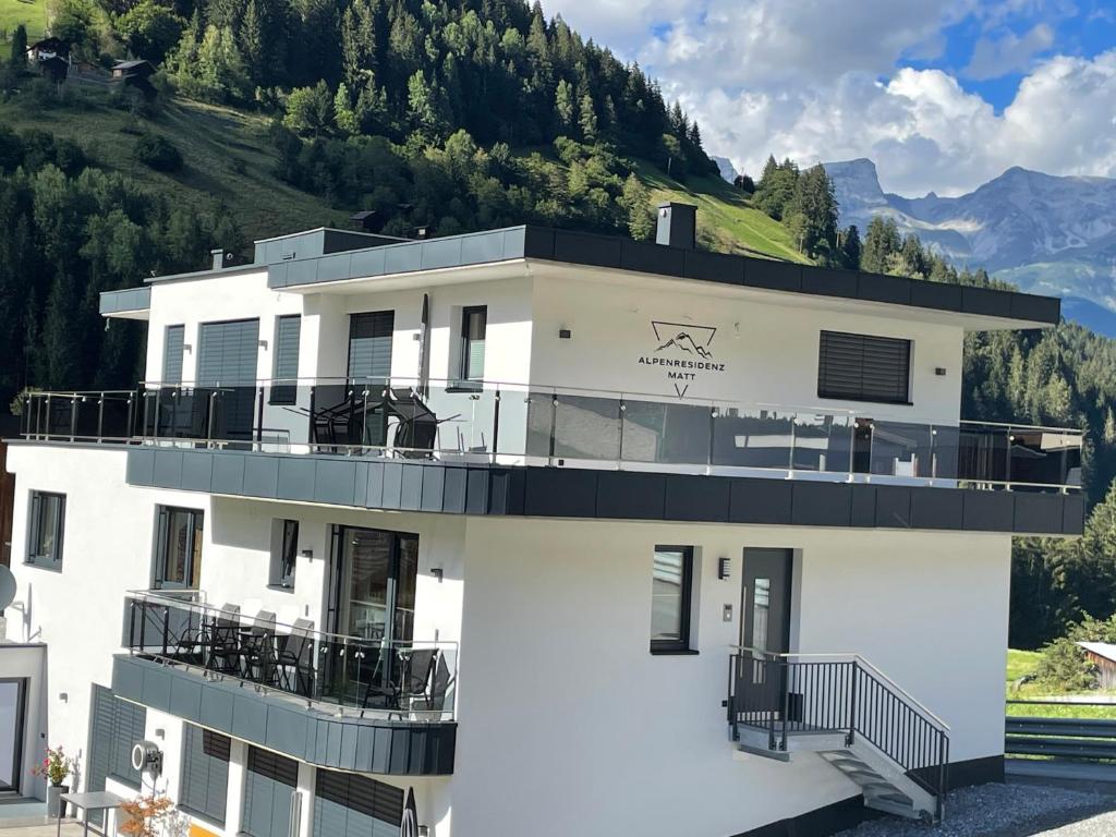 - un bâtiment blanc avec un balcon en haut dans l'établissement Alpenresidenz M Vermietungs KG, à See