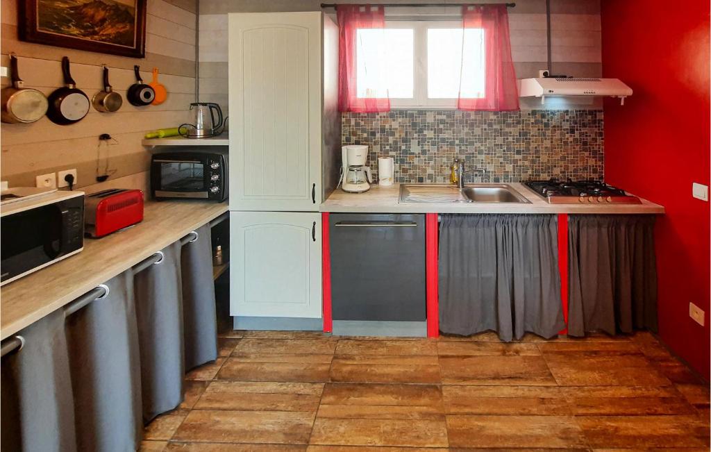 a kitchen with red and white cabinets and a sink at 2 Bedroom Lovely Home In Plogoff in Plogoff