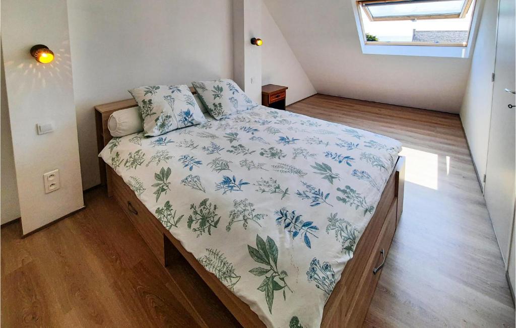 a small bedroom with a bed with a floral bedspread at 2 Bedroom Lovely Home In Plogoff in Plogoff