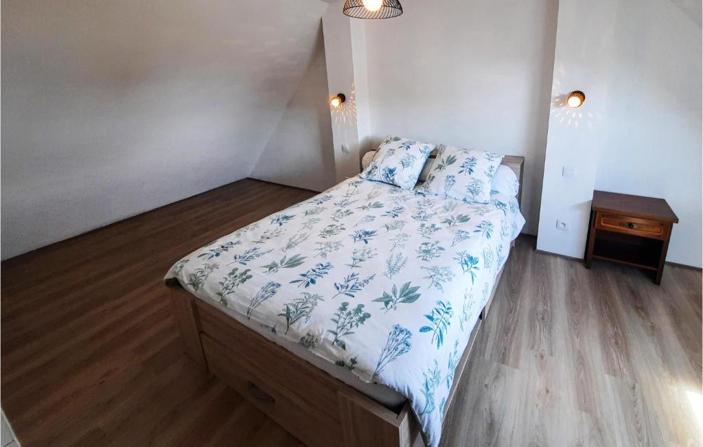 a small bedroom with a bed with blue and white sheets at 2 Bedroom Lovely Home In Plogoff in Plogoff