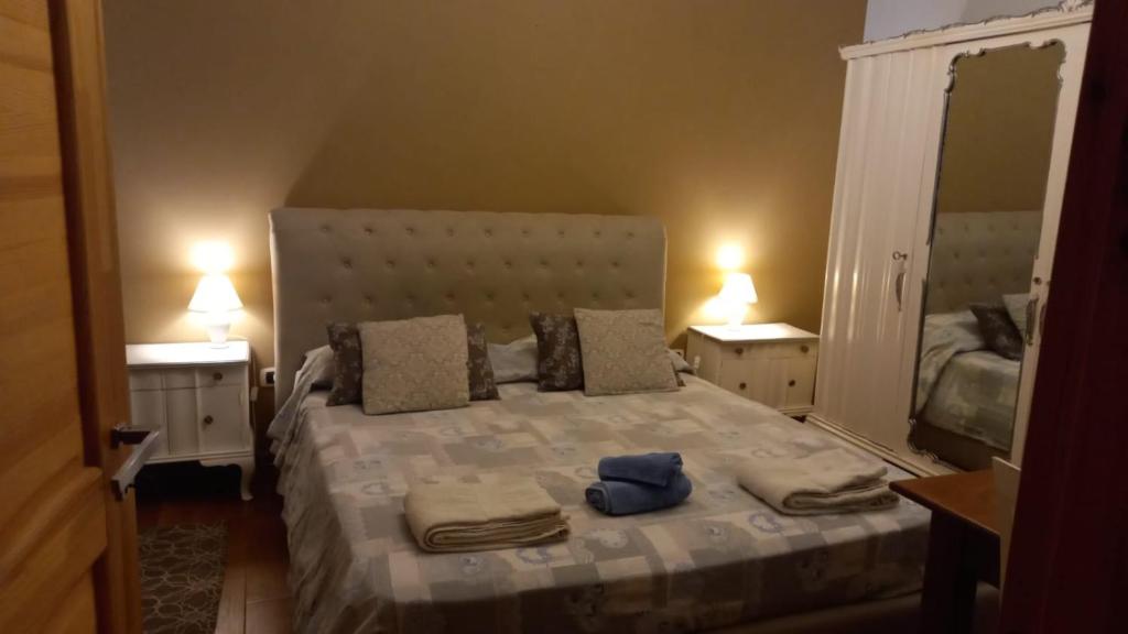 - une chambre avec un grand lit et 2 tables de chevet dans l'établissement B&B Ulivi d'argento, à Cavallino di Lecce