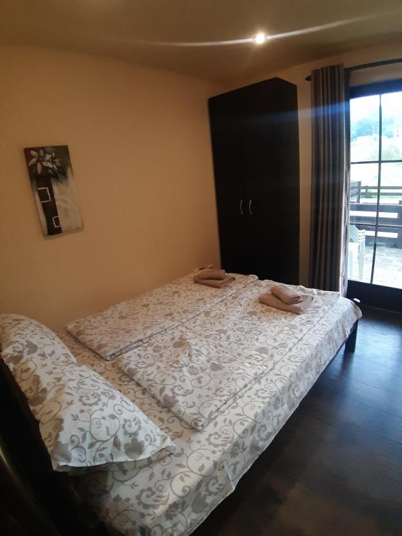 a bedroom with a bed with two towels on it at Apartman Popadić-Goč in Biserske Kuće