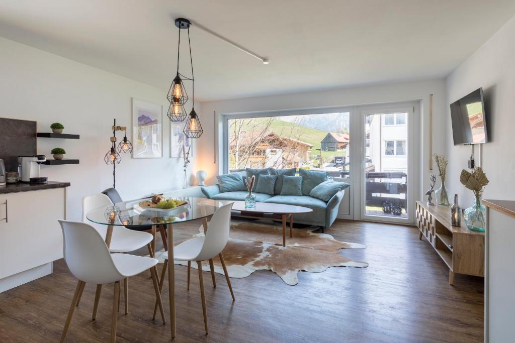 a living room with a table and a couch at Design Apartment „Alpenglühen“ nahe Breitachklamm in Oberstdorf