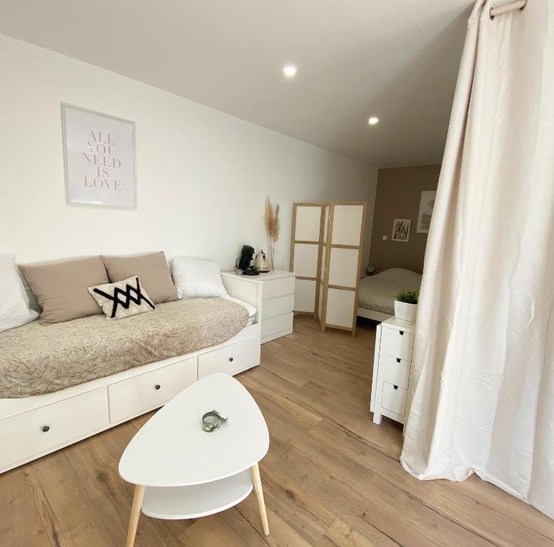 1 dormitorio con 1 cama blanca y 1 silla blanca en maison moderne proche centre ville/hôpital, en Angers