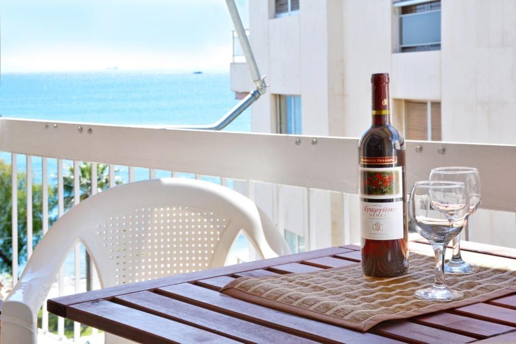 a bottle of wine sitting on a table with wine glasses at Luxury at its best beach condo in Palaio Faliro in Athens