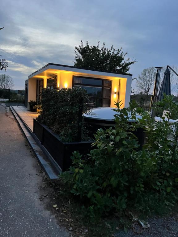 a small house with a tub in front of it at Luxus Chalet Hafenblick in Lathum