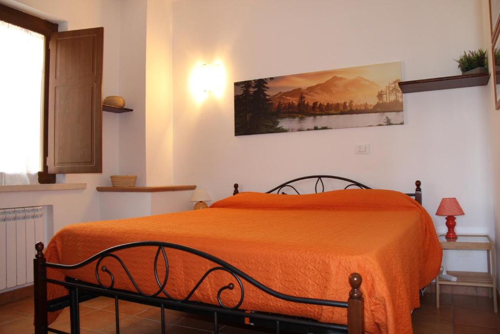 a bedroom with a bed with an orange blanket at Il Pagliarello di Villa San Giovanni in San Demetrio neʼ Vestini