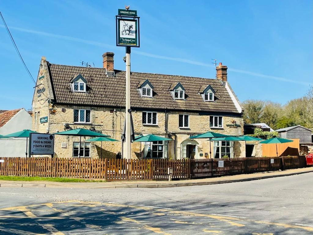 ein Gebäude mit einer Uhr davor in der Unterkunft The Woolpack Inn in Kettering