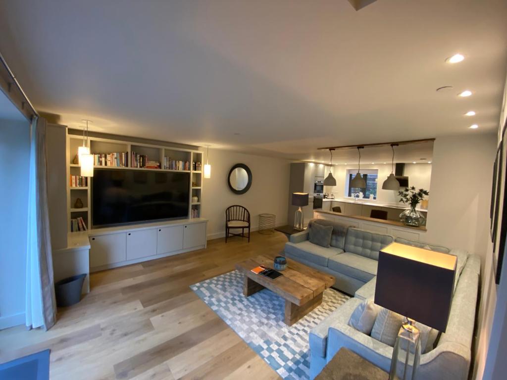 a living room with a couch and a tv at Linhay Cottages in Box