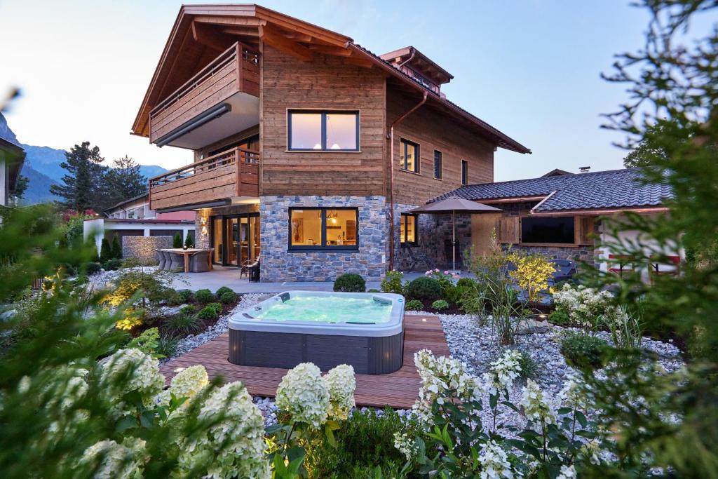 a house with a hot tub in the middle of a garden at Sunshine Apartment Spirit of Deer in Garmisch-Partenkirchen