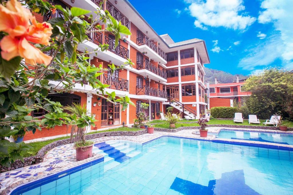 un hotel con piscina frente a un edificio en Alisamay Hotel en Baños