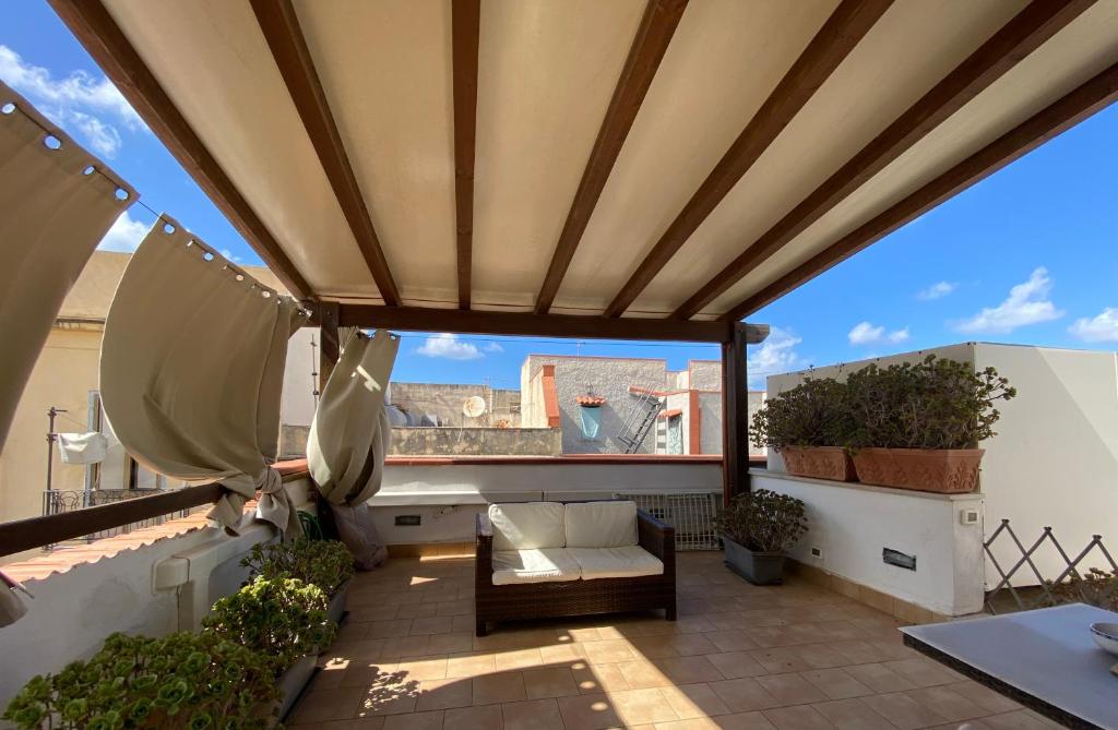 a patio with awning and a view of the city at Mansarda con terrazzo in Trapani