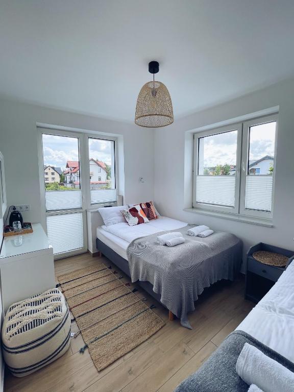 una camera da letto con due letti e due finestre di Ostrovia - pokoje nad morzem a Ostrowo