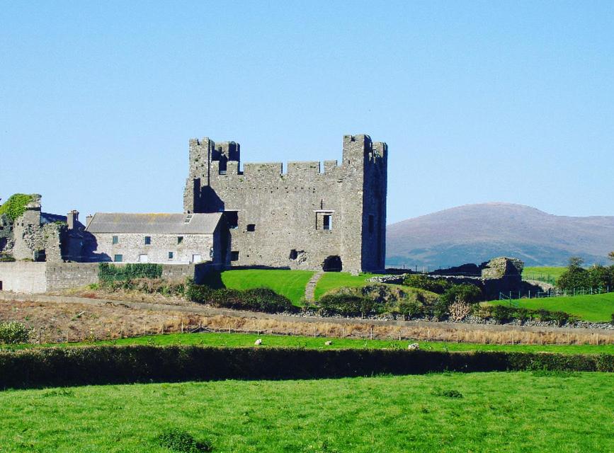 an old castle on top of a green field at The Loft - Shemara 